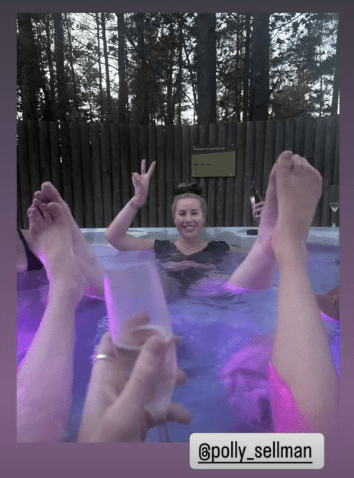 a woman is laying in a hot tub holding a glass of wine