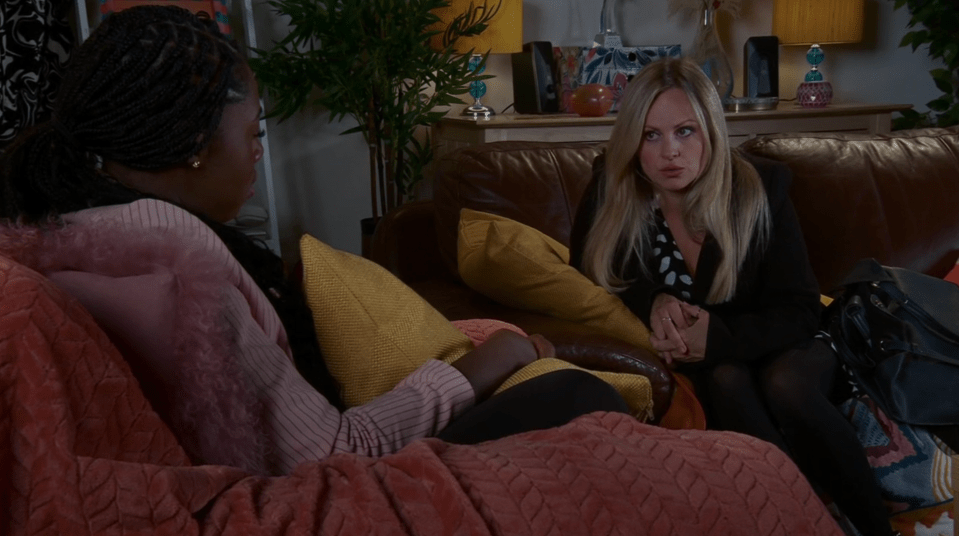 two women sit on a couch talking to each other