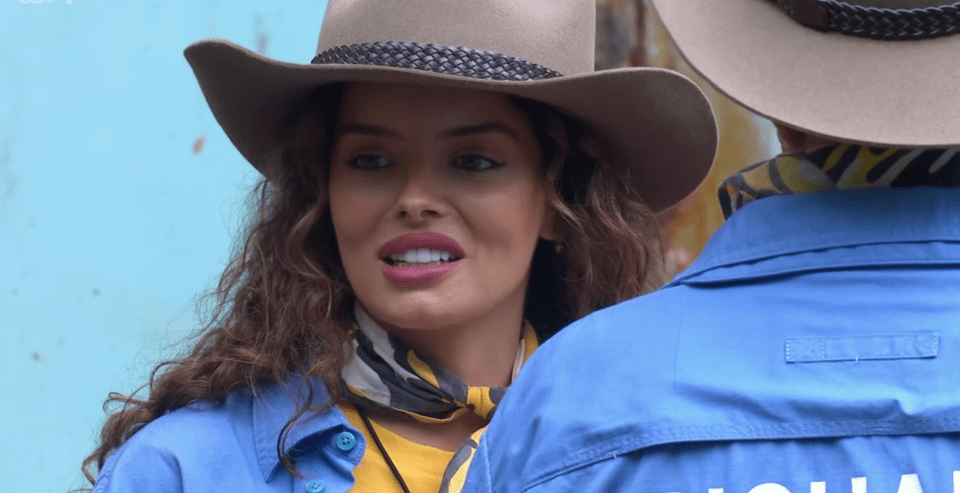 a woman wearing a cowboy hat stands next to a man in a blue jacket