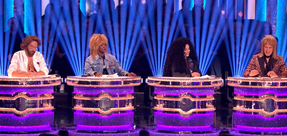 a group of people are sitting at purple tables on a stage