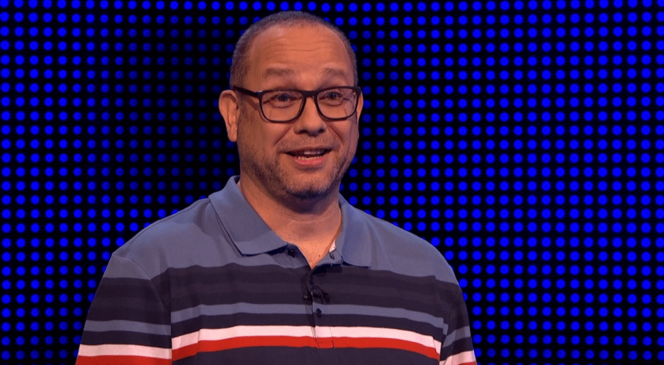 a man wearing glasses and a striped shirt is smiling