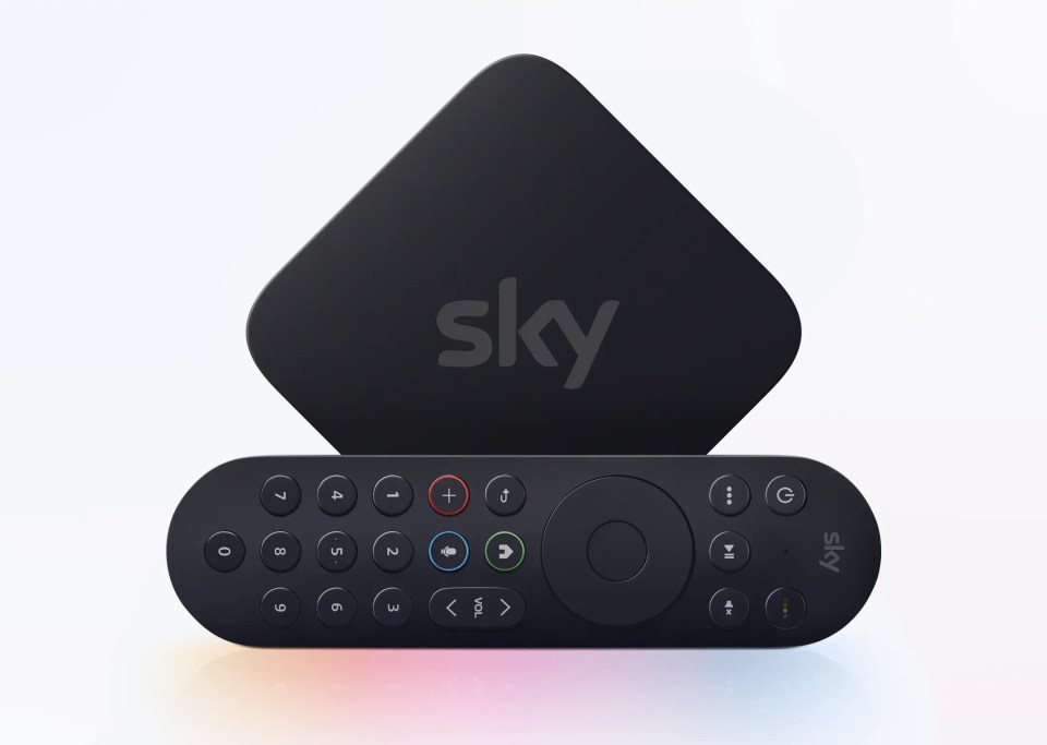 a black sky box sits next to a black remote control