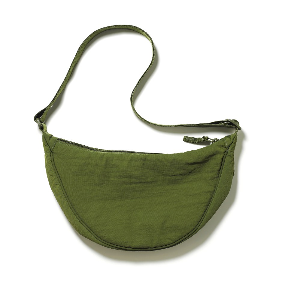 a green purse with a long strap on a white background