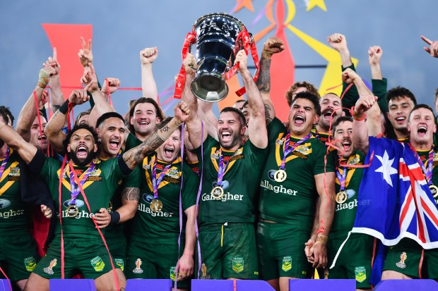 a group of rugby players holding up a trophy with allagher on their shirts