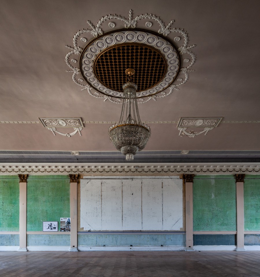 an empty room with a chandelier hanging from the ceiling