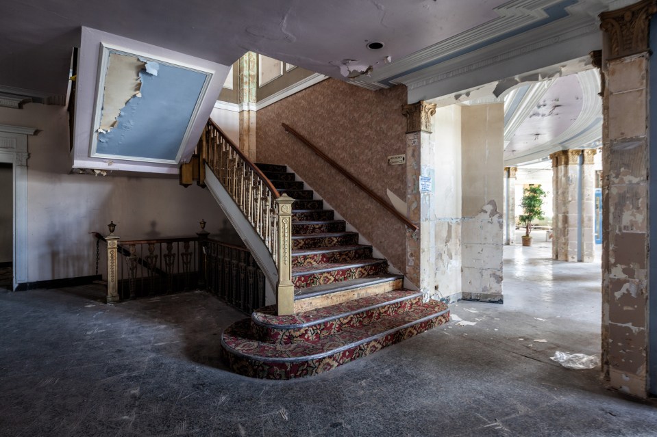 a staircase in an old building with a sign on the wall that says ' emergency exit '