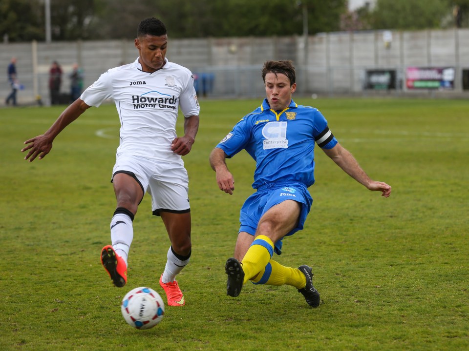 two soccer players on a field with one wearing a jersey that says howard motor group