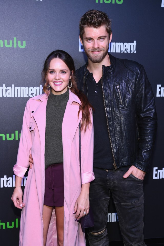 a woman in a pink coat and a man in a black leather jacket pose for a photo