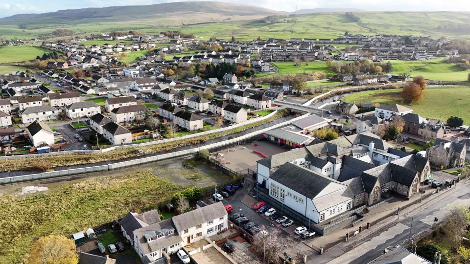 An aerial view of a rural countryside under a bright sky in New Cumnock, Scotland