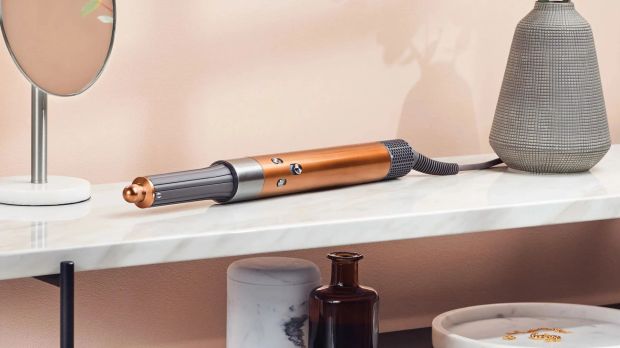 a hair dryer sits on a marble counter next to a mirror