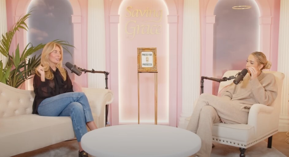 two women are sitting in front of a sign that says saving grace