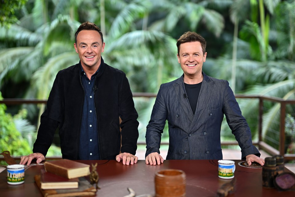 two men standing next to each other with a cup that says i 'm a celebrity on it