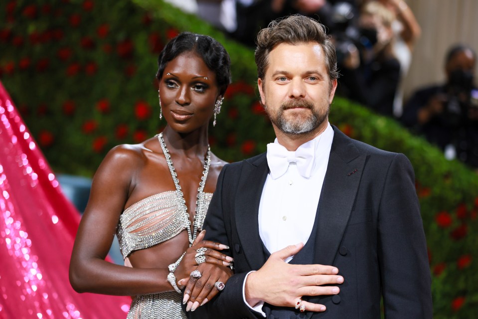 a man in a tuxedo stands next to a woman in a dress