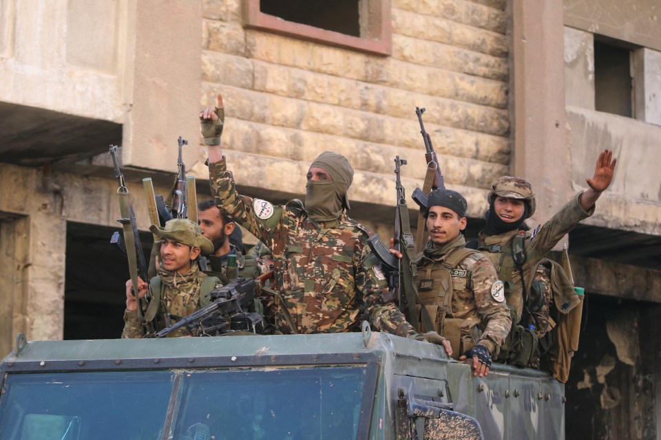 Armed rebels celebrate in a street in Maaret al-Numan in Syria’s northwestern Idlib province