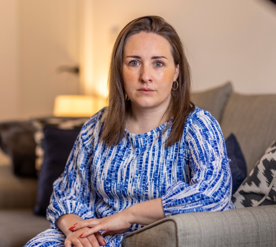 a woman in a blue and white dress sits on a couch