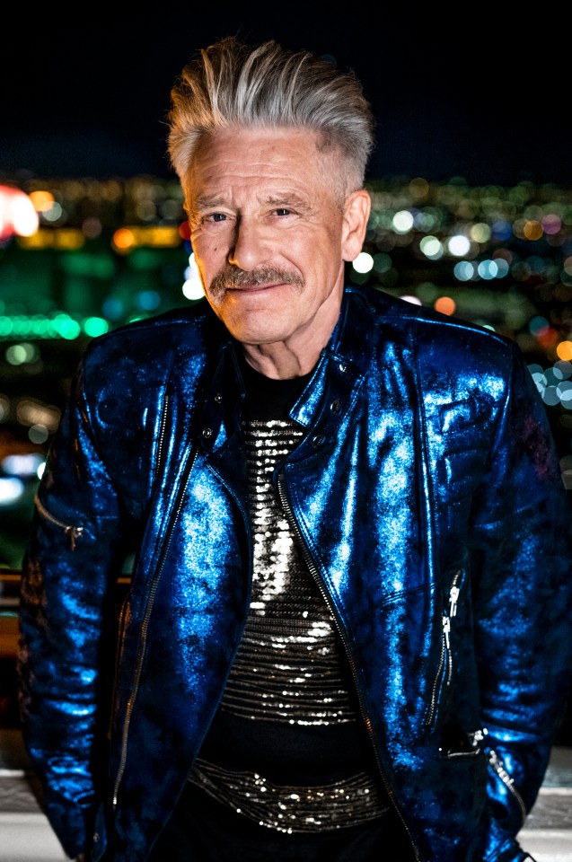 a man with a mustache is wearing a blue jacket