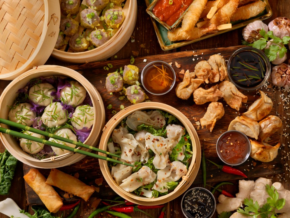 a wooden table topped with a variety of asian food