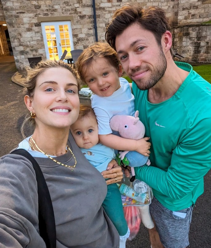 a man in a green nike shirt is holding two children