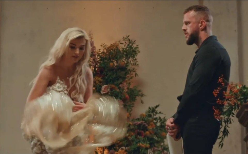 a man and a woman are standing in front of flowers