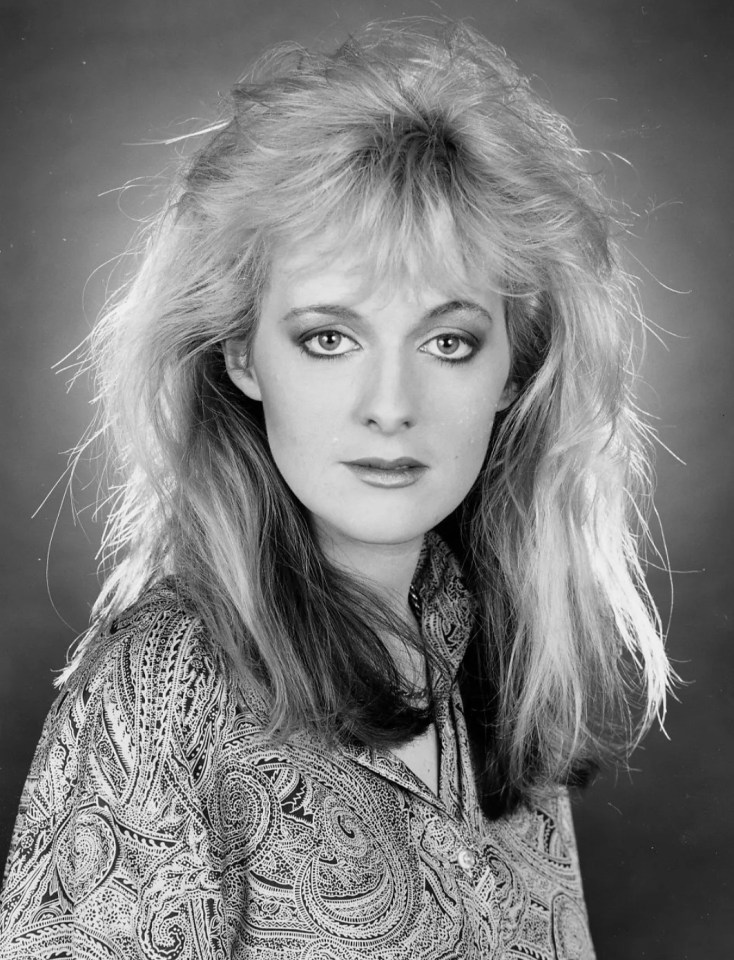 a black and white photo of a woman wearing a paisley shirt