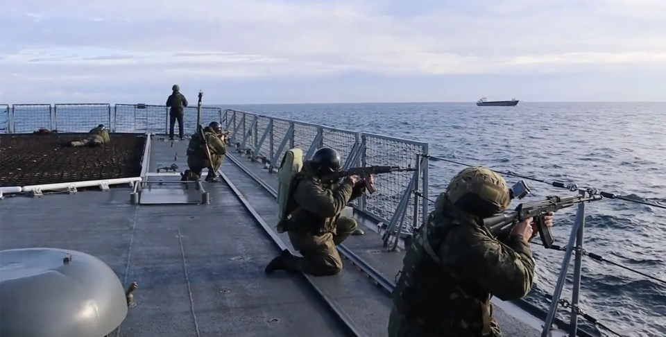 Russian troops aim guns on board the ship