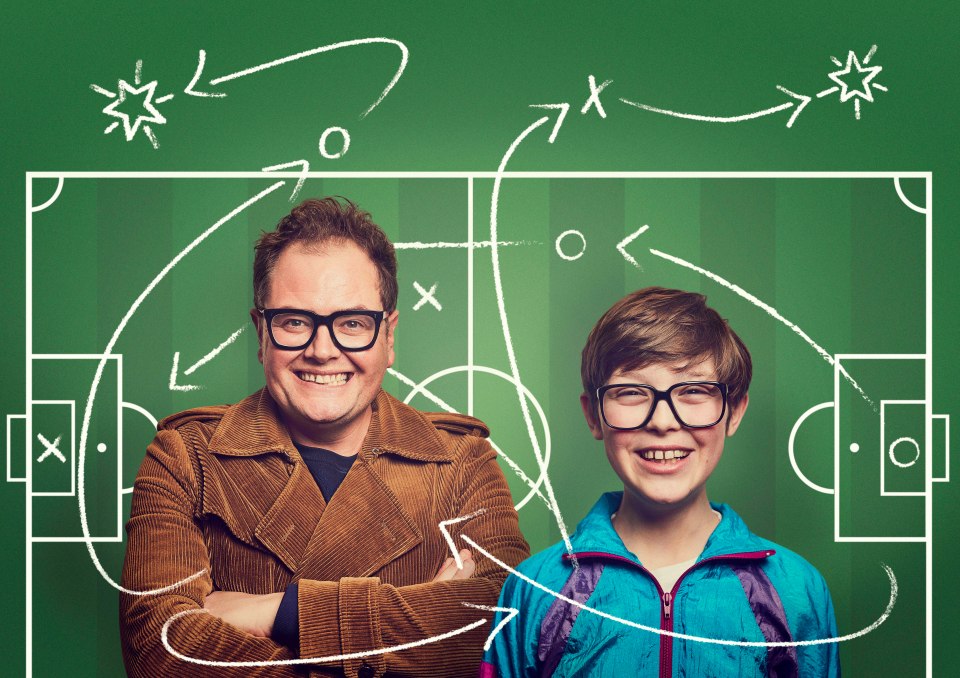 a man and a boy are standing in front of a chalkboard with a soccer field drawn on it