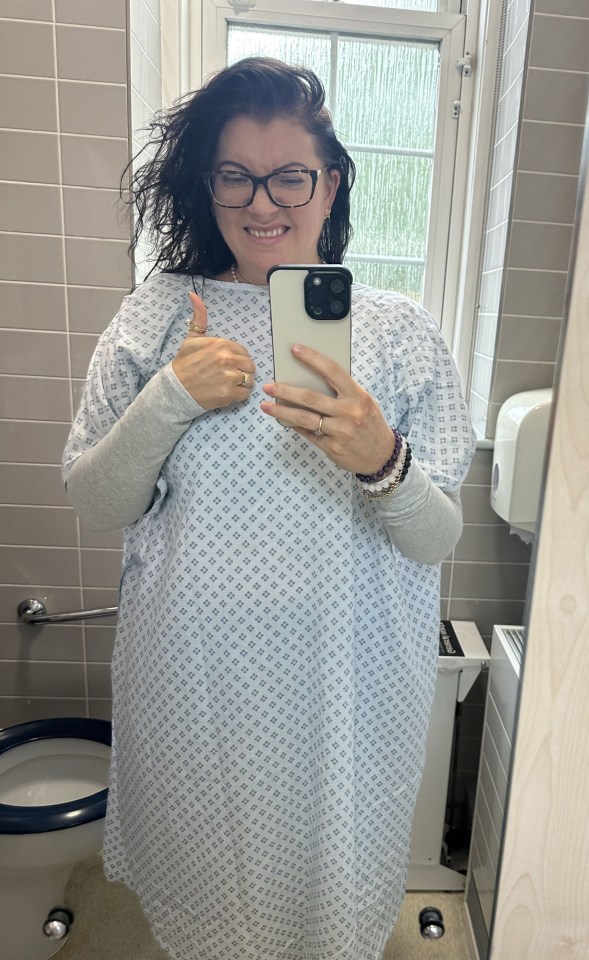 a woman in a hospital gown is taking a selfie