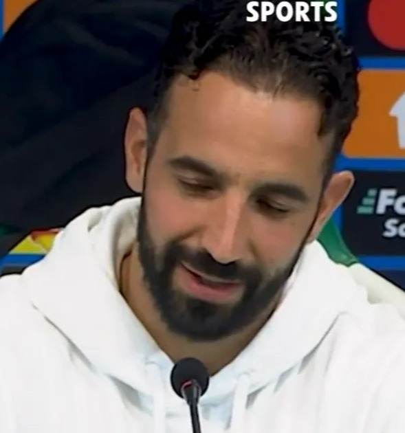 a man with a beard stands in front of a sign that says beanyman sports