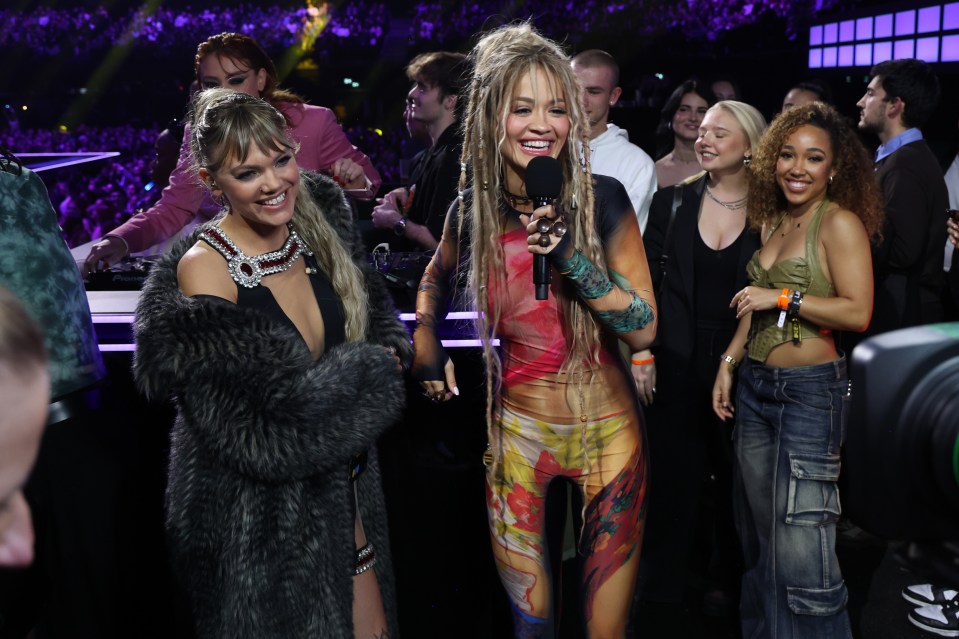 Rita flaunted her slim figure in a slinky bodysuit as she presented the backstage bar segment with Becca Dudley