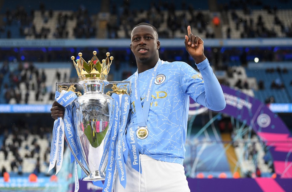 a man holding a trophy that says premier league on it