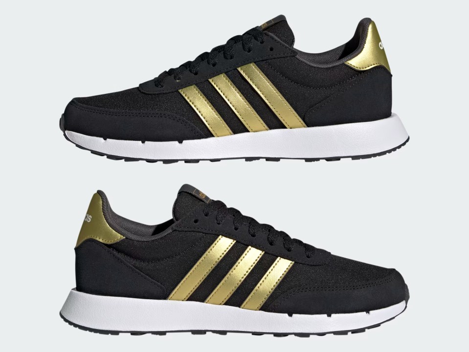 a pair of black and gold adidas shoes on a white background