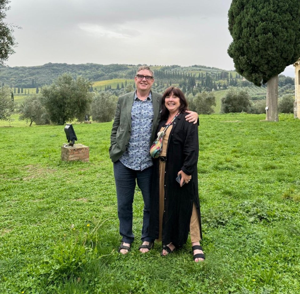 a man and a woman standing in a grassy field