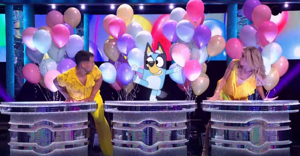 a man and a woman are dancing in front of a bunch of balloons