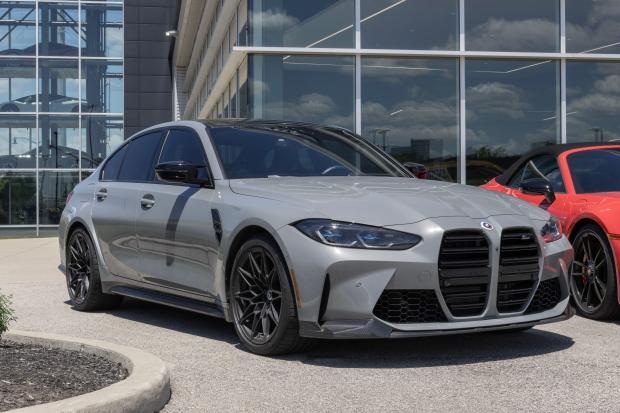 a silver bmw is parked in front of a building