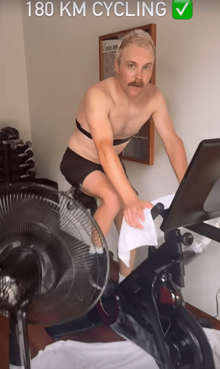 a shirtless man is riding an exercise bike with the words 180 km cycling above him