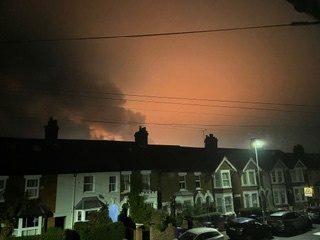 a row of houses with a red sky in the background