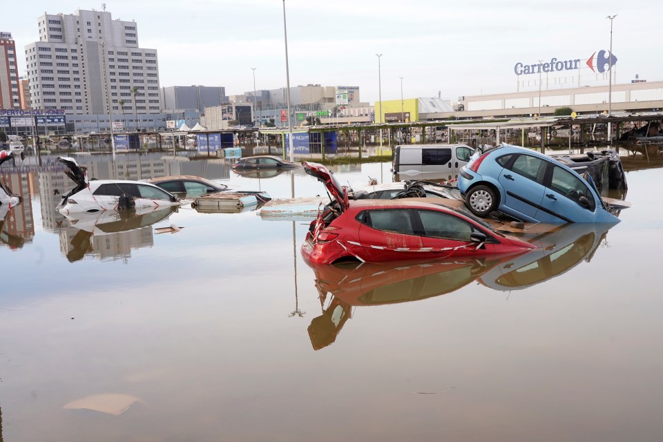 a flooded parking lot in front of a carrefour store