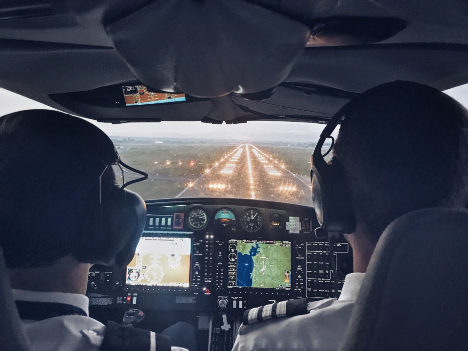 two pilots are in the cockpit of a plane with a gps on the dashboard