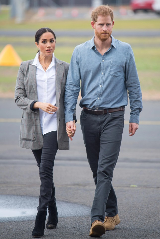 a man and a woman are walking down the street holding hands