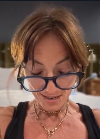 a close up of a woman wearing glasses and a necklace