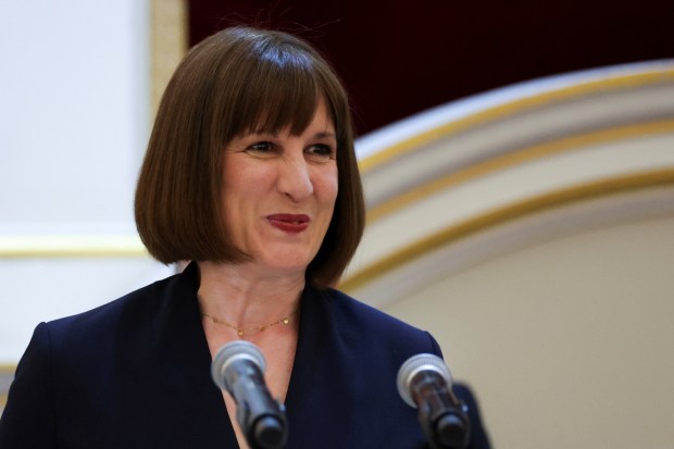 a woman stands in front of two microphones and smiles