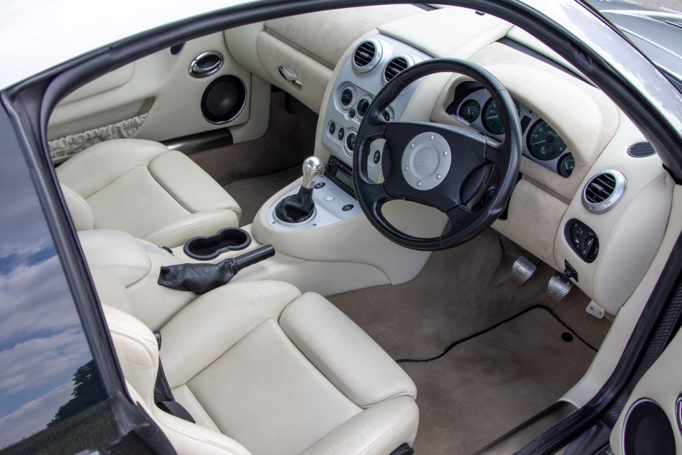 the inside of a car with a steering wheel that says ' jaguar ' on it