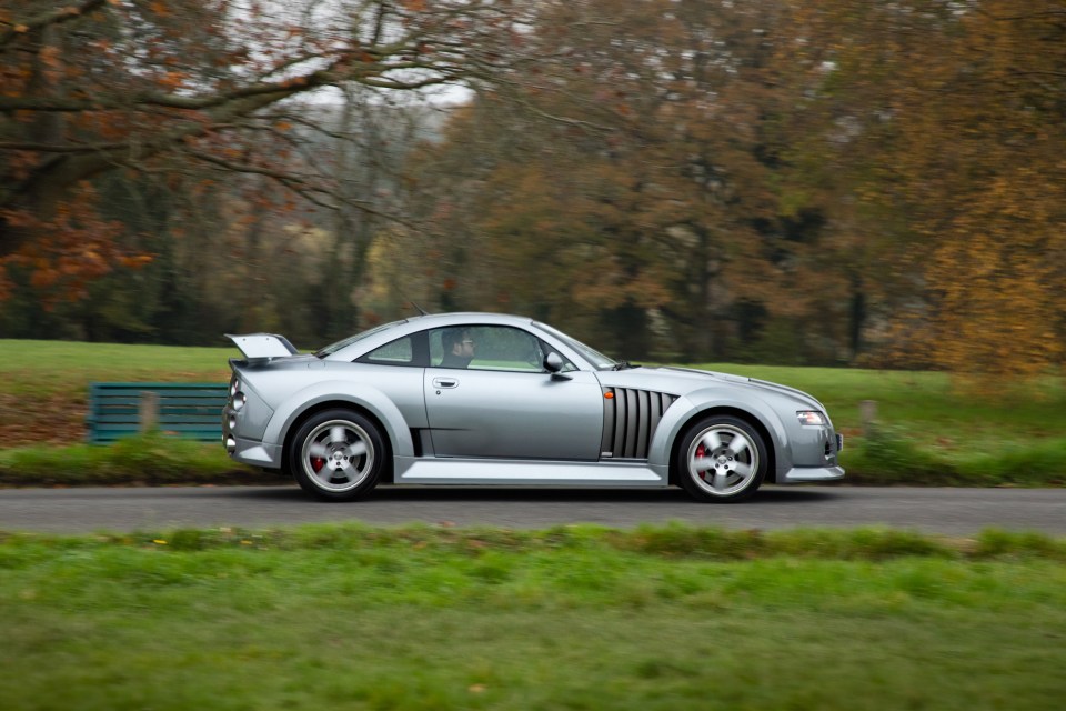 a silver sports car is driving down a road