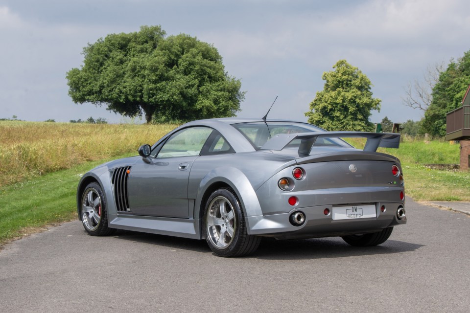 a silver sports car is parked on the side of the road