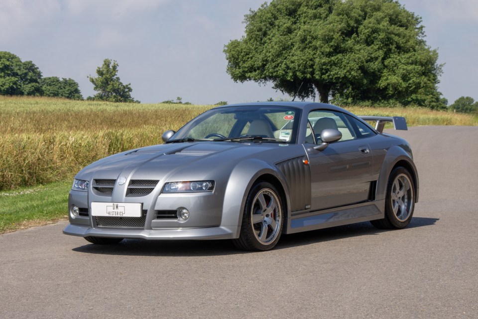 a silver sports car is parked on the side of the road