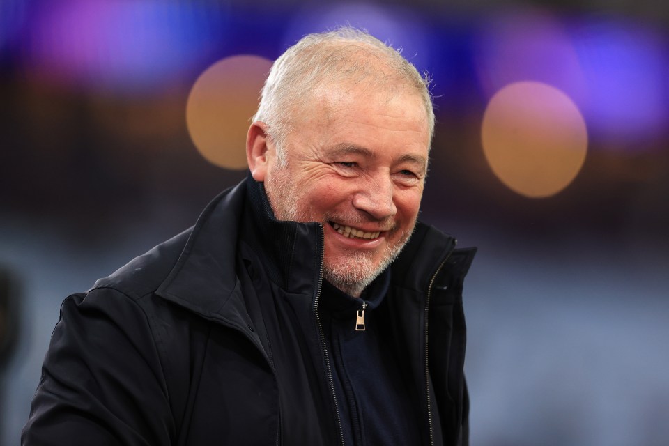 a man with a beard wearing a black jacket smiles