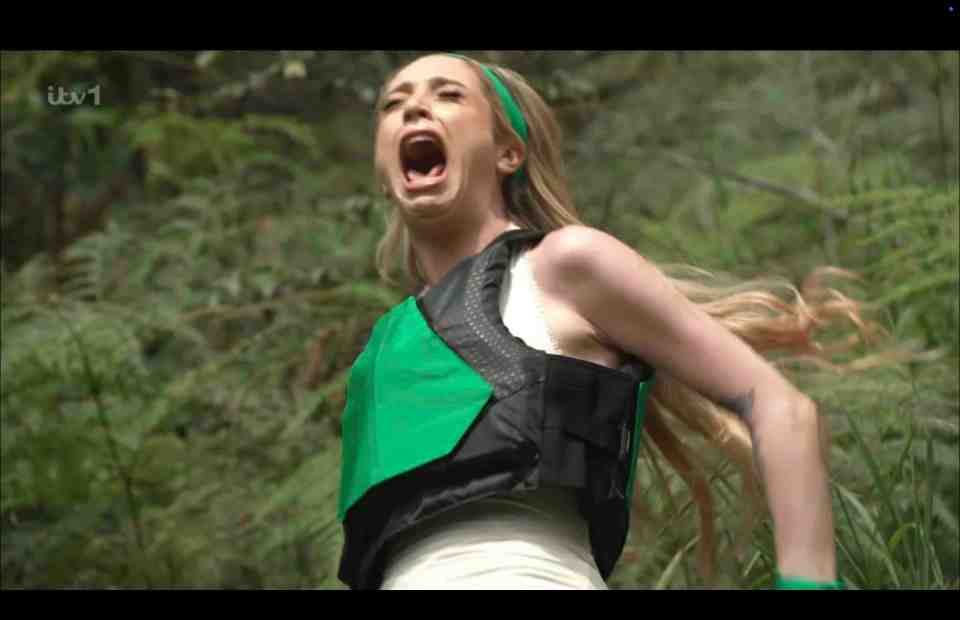 a woman in a green vest is screaming in the woods on itv 1