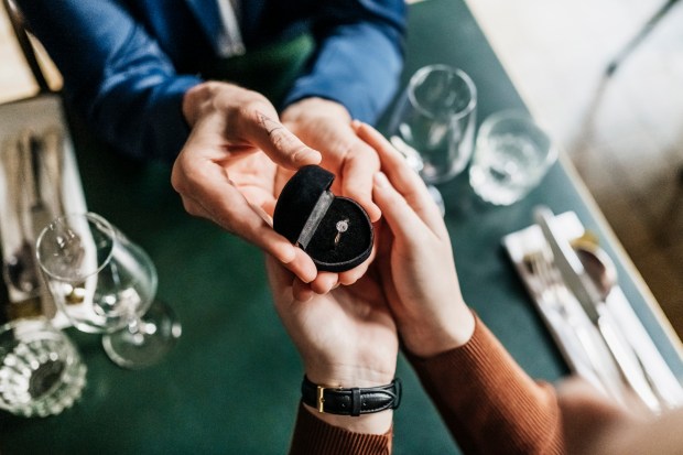 a man is giving a woman an engagement ring