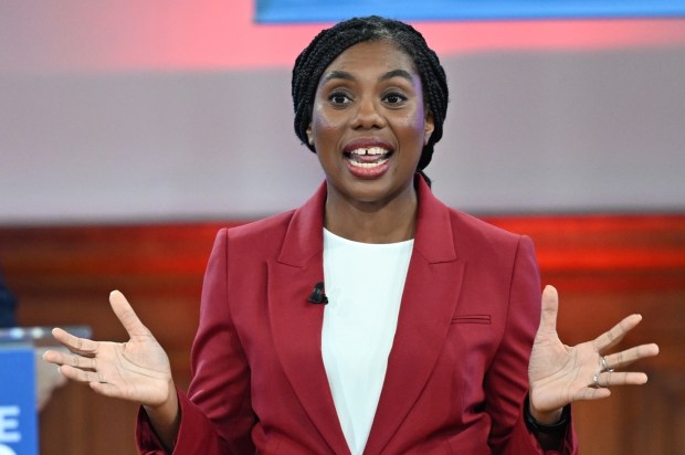 a woman in a red suit is giving a speech