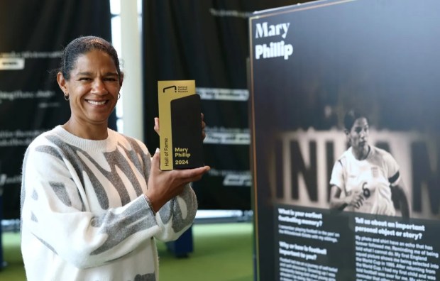 a woman holding a mary phillip 2024 plaque